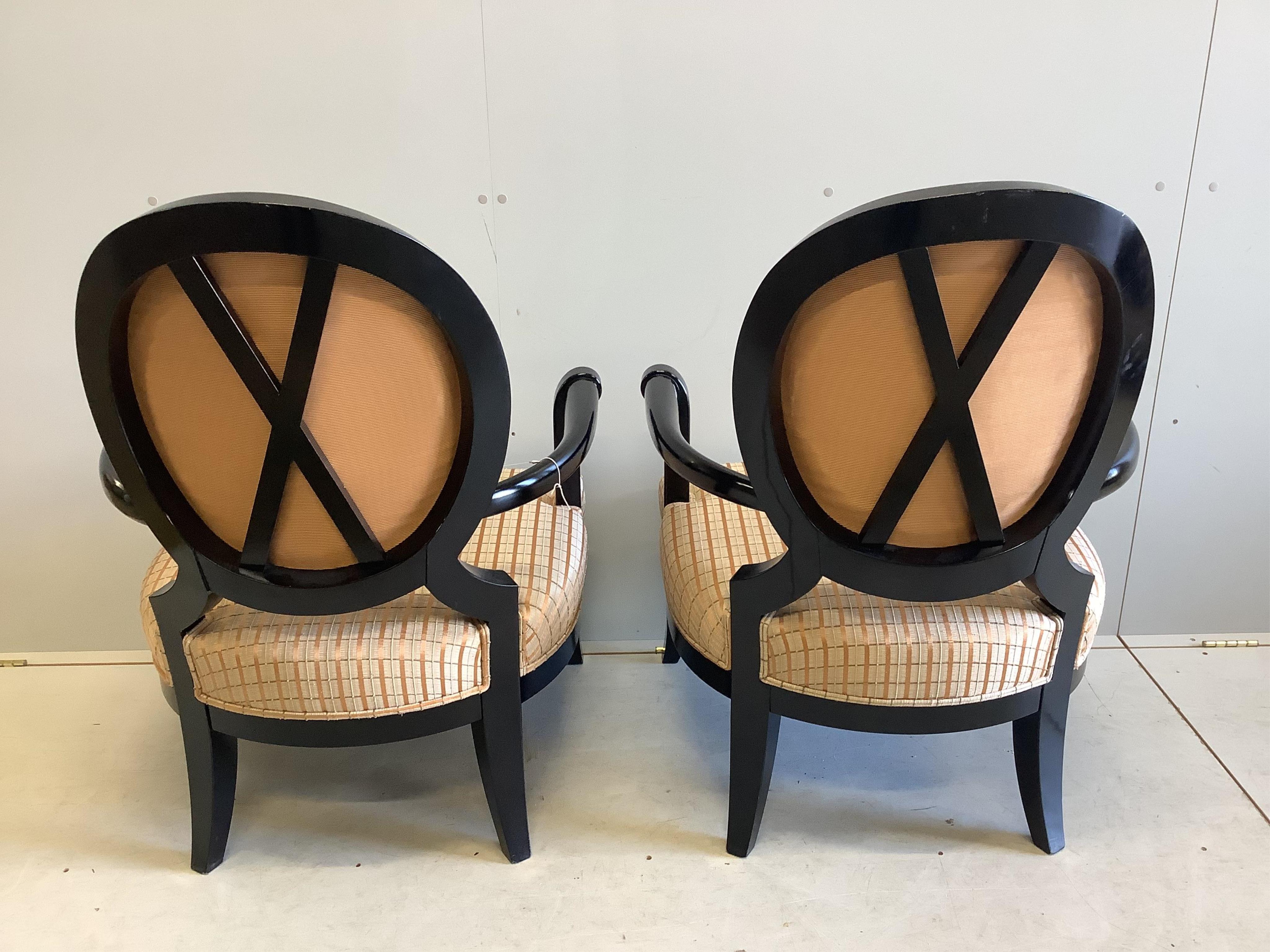 A pair of James Martin ebonised elbow chairs, width 74cm, depth 60cm, height 100cm. Condition - good